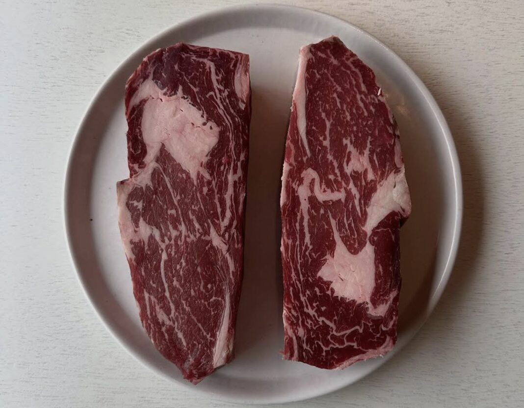 Two cuts of marbled beef on a plate